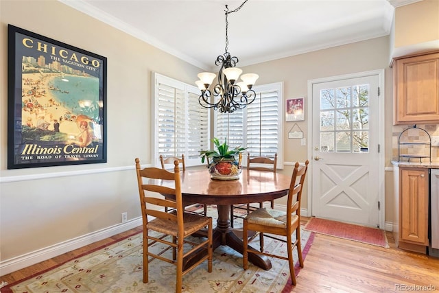 dining space with a notable chandelier, ornamental molding, baseboards, and light wood-style floors