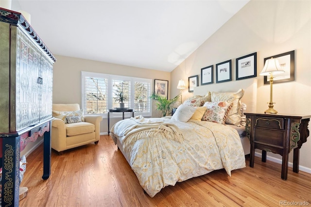 bedroom featuring baseboards, vaulted ceiling, and wood finished floors