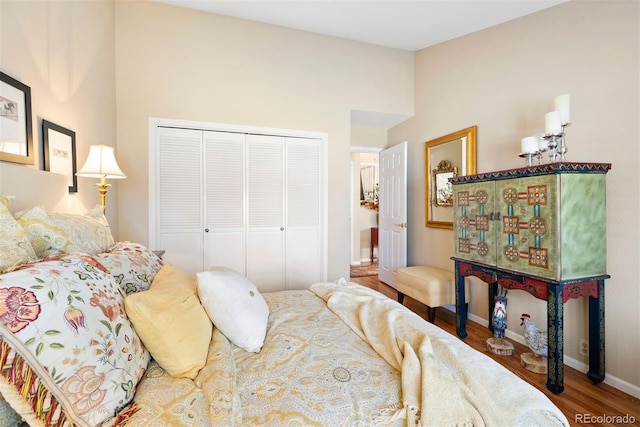 bedroom with a closet, baseboards, and wood finished floors