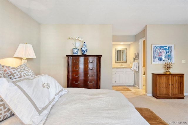 carpeted bedroom featuring connected bathroom and baseboards