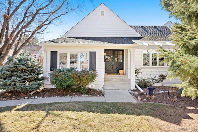 view of front of property with a shingled roof and a front lawn