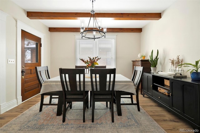 dining area featuring beamed ceiling, hardwood / wood-style flooring, and a chandelier