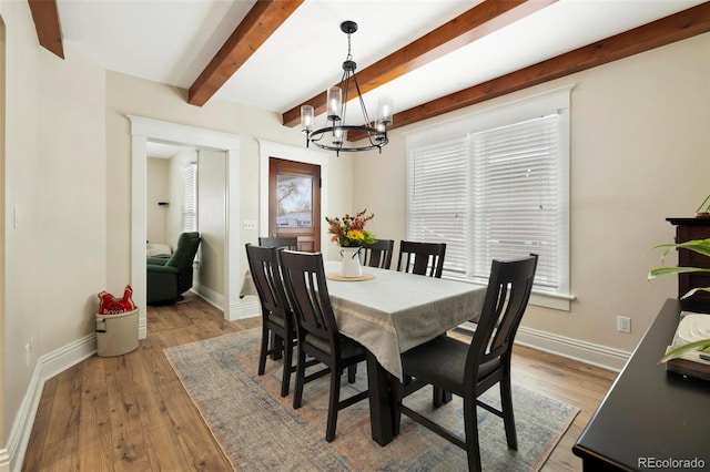 dining space featuring an inviting chandelier, light hardwood / wood-style floors, and beamed ceiling