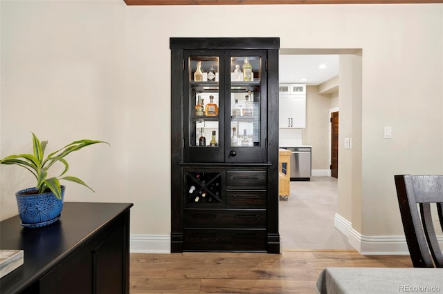 details with hardwood / wood-style flooring, stainless steel dishwasher, and backsplash