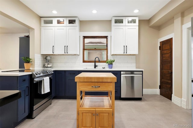 kitchen featuring appliances with stainless steel finishes, sink, white cabinets, and backsplash