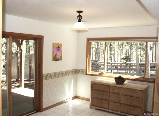 9274 Sandy Ln, Conifer, CO 80433 - unfurnished dining area with plenty of natural light, light tile patterned floors, a textured ceiling, and baseboards