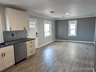 kitchen featuring dark countertops, dishwasher, wood finished floors, and a healthy amount of sunlight