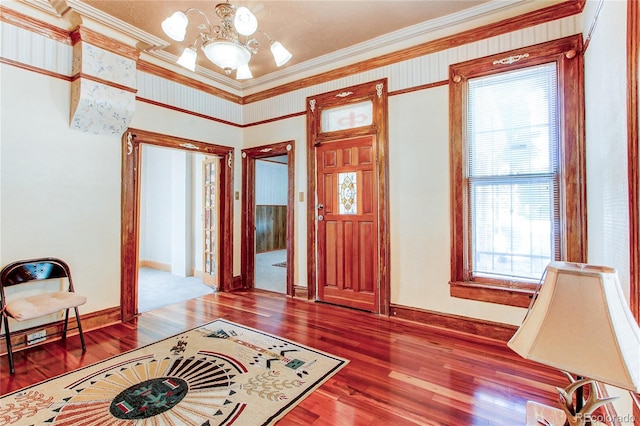 entrance foyer featuring hardwood / wood-style flooring, a notable chandelier, and crown molding