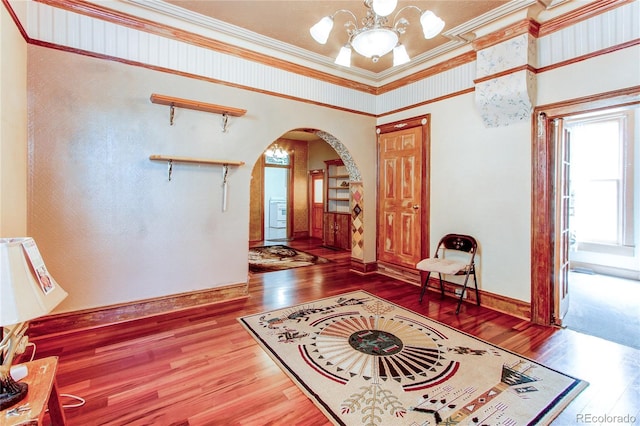 interior space featuring hardwood / wood-style floors, crown molding, and a notable chandelier