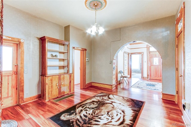 foyer with hardwood / wood-style flooring and a notable chandelier