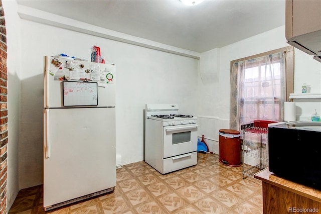 kitchen featuring white appliances, brick wall, and light parquet floors