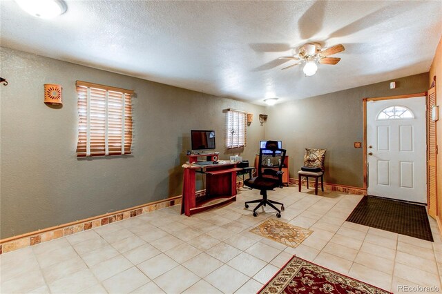 office featuring a wealth of natural light, ceiling fan, and light tile patterned floors