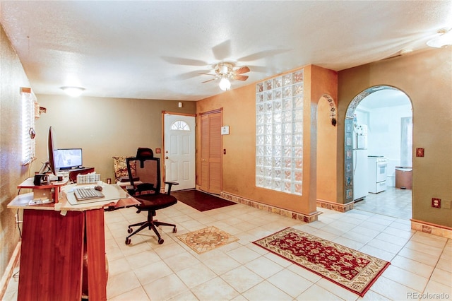 entrance foyer with light tile patterned flooring, ceiling fan, and a textured ceiling