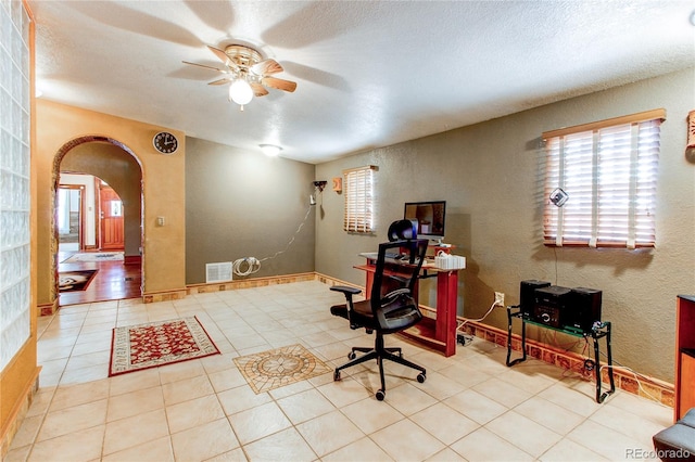 tiled office space with ceiling fan, a textured ceiling, and a healthy amount of sunlight