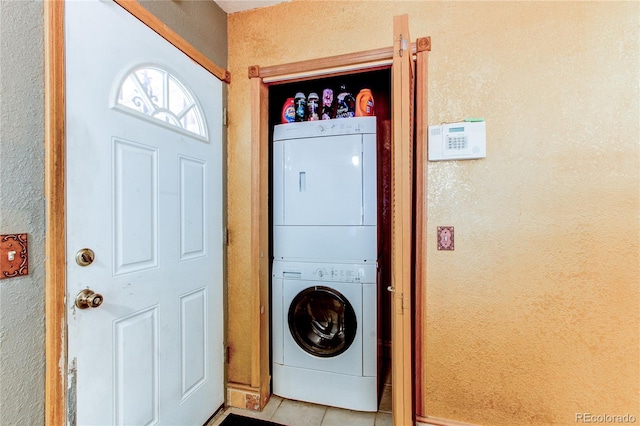 clothes washing area with stacked washer / dryer and light tile patterned flooring