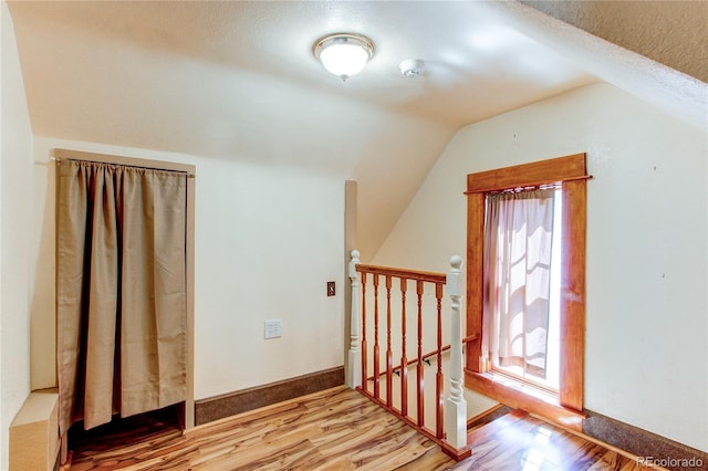 additional living space featuring hardwood / wood-style flooring and lofted ceiling