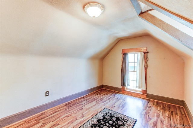 bonus room with light hardwood / wood-style floors and lofted ceiling