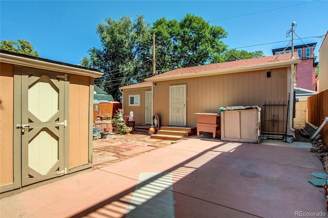 rear view of house featuring a storage shed and a patio