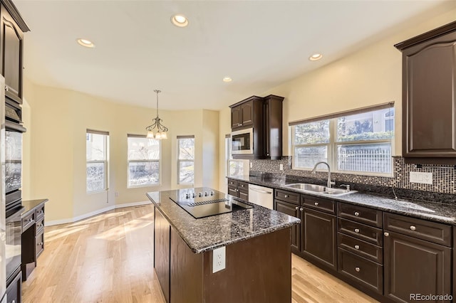 kitchen with plenty of natural light, appliances with stainless steel finishes, decorative backsplash, and a sink