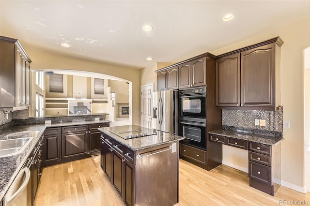 kitchen with black appliances, dark brown cabinetry, and light wood-style floors