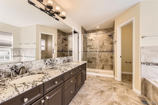 bathroom featuring a stall shower, a sink, toilet, and double vanity