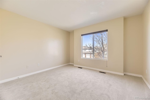 spare room with light carpet, baseboards, and visible vents