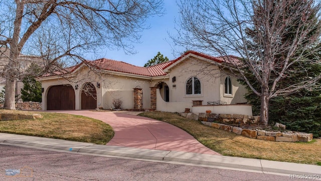 7022 Secrest Ct, Arvada, CO 80007 - mediterranean / spanish home featuring an attached garage, driveway, stucco siding, a front yard, and a tiled roof