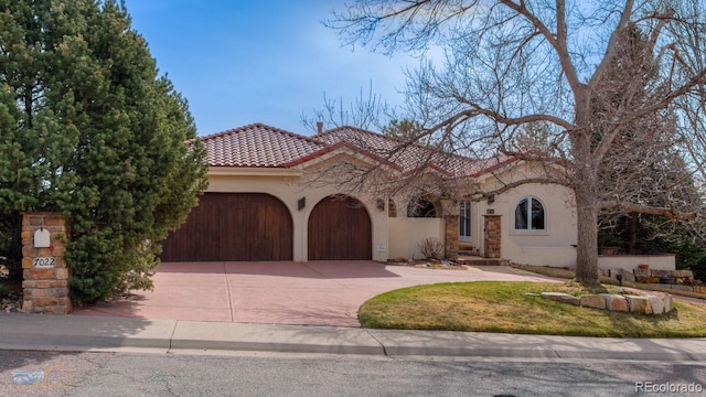 7022 Secrest Ct, Arvada, CO 80007 - mediterranean / spanish home featuring stone siding, a garage, a tiled roof, stucco siding, and concrete driveway