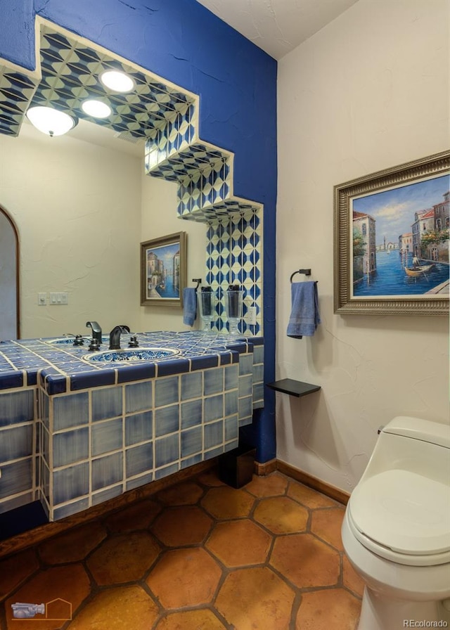 7022 Secrest Ct, Arvada, CO 80007 - bathroom with toilet, baseboards, and a sink