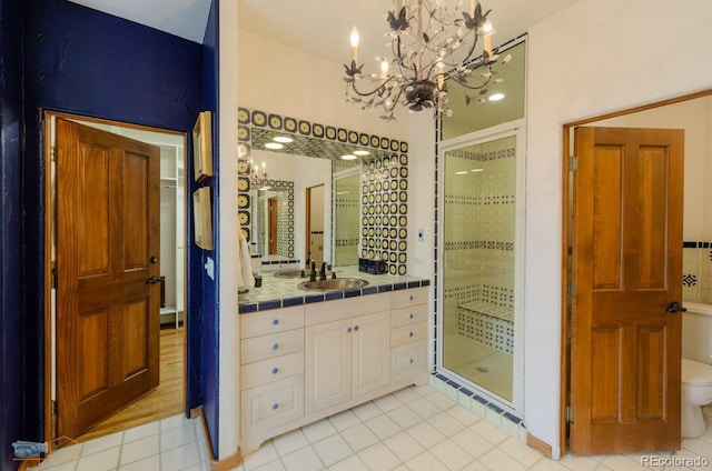 7022 Secrest Ct, Arvada, CO 80007 - bathroom featuring a shower stall, a notable chandelier, tile patterned floors, and vanity