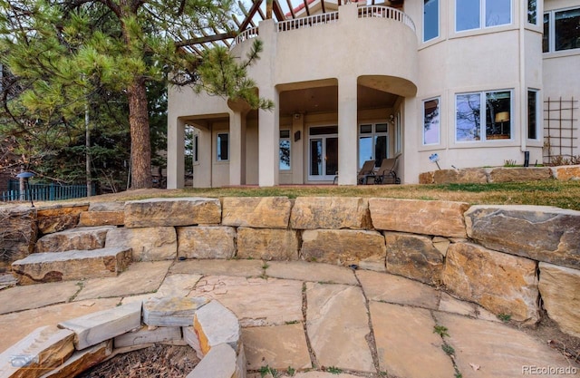 7022 Secrest Ct, Arvada, CO 80007 - rear view of house with a balcony, a patio area, stucco siding, and french doors