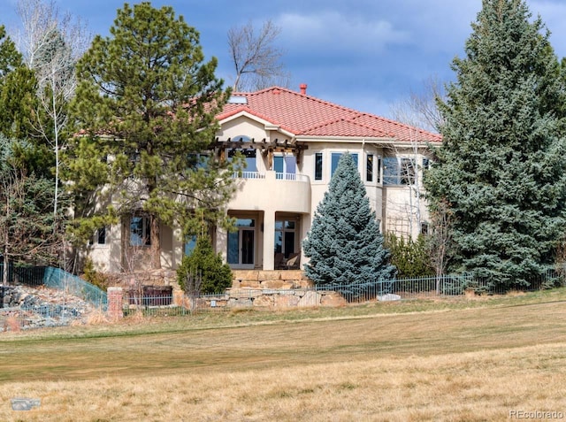 7022 Secrest Ct, Arvada, CO 80007 - back of house featuring a balcony, stucco siding, a tile roof, and fence