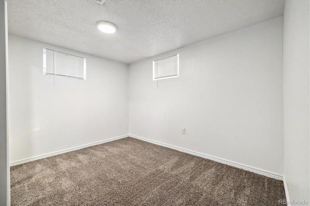 carpeted spare room with a textured ceiling