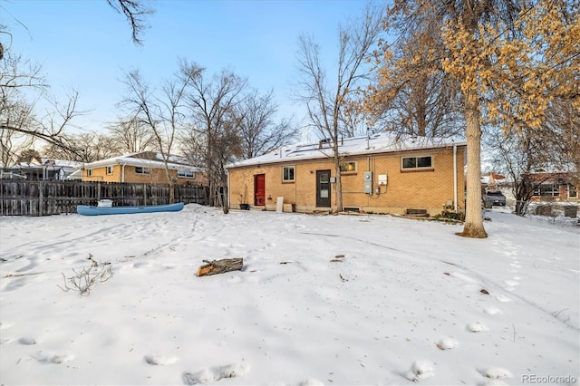 view of snow covered back of property