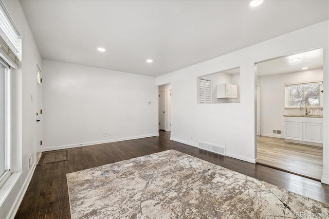 spare room with recessed lighting, visible vents, baseboards, and wood finished floors