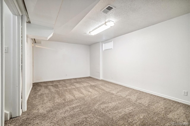 empty room featuring baseboards, carpet, visible vents, and a textured ceiling