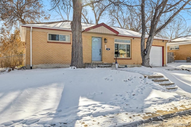 view of front of home with a garage, brick siding, and fence