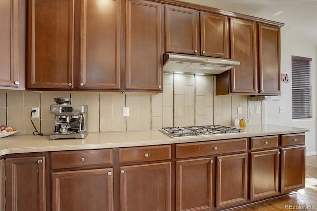 kitchen featuring light hardwood / wood-style flooring, stainless steel gas stovetop, and tasteful backsplash