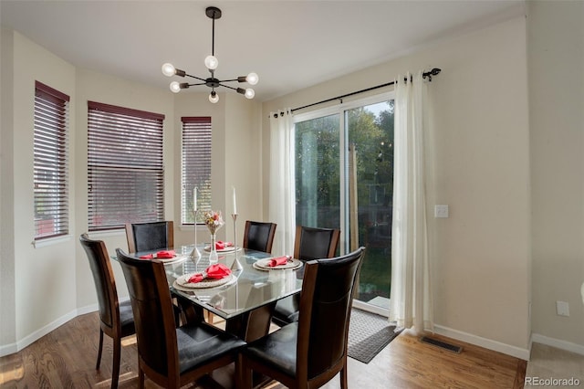 dining space with a notable chandelier and hardwood / wood-style flooring