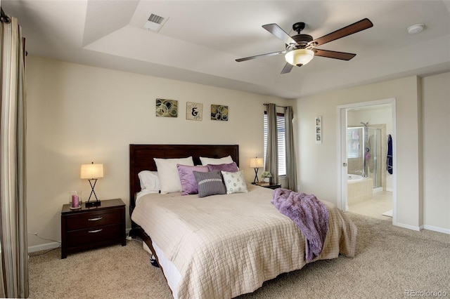 bedroom with light colored carpet, connected bathroom, and ceiling fan