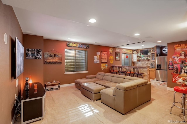 carpeted living room featuring bar area