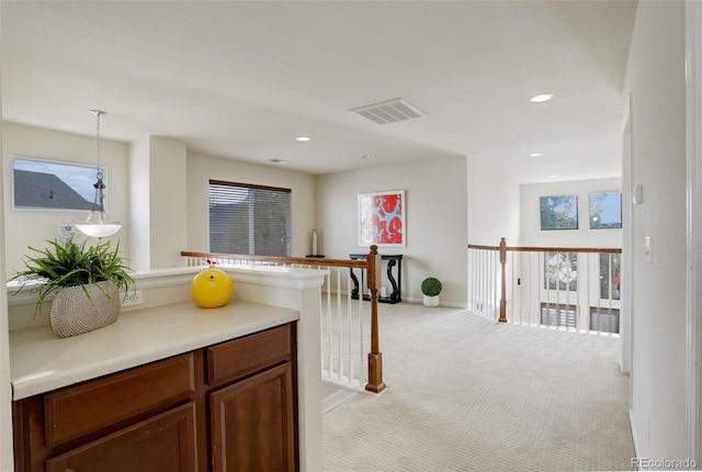 kitchen with light carpet, hanging light fixtures, and a wealth of natural light