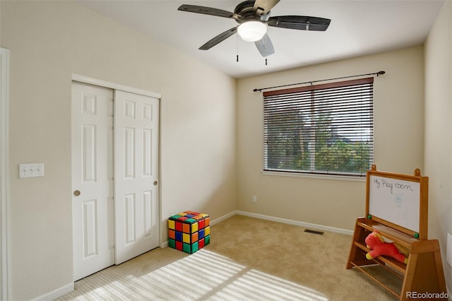 game room with ceiling fan and light colored carpet