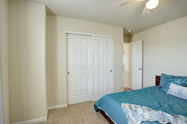 bedroom featuring light colored carpet, a closet, and ceiling fan