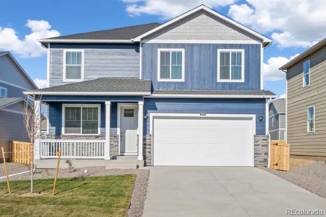 view of front of home featuring a front lawn, a porch, and a garage