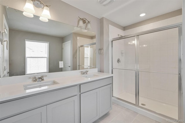 bathroom with tile patterned flooring, vanity, and a shower with door