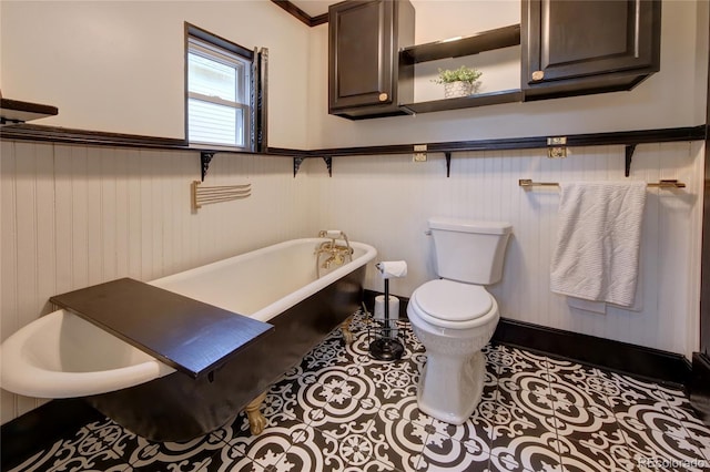 114 N 7th St, Colorado Springs, CO 80905 - bathroom featuring tile patterned floors, a freestanding bath, a wainscoted wall, and toilet