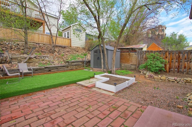 114 N 7th St, Colorado Springs, CO 80905 - view of patio with an outbuilding, a shed, a fenced backyard, and a garden