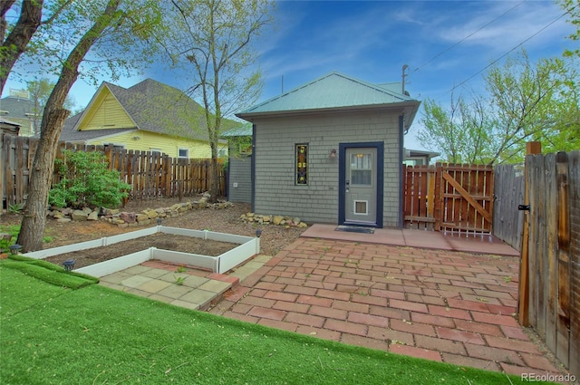 114 N 7th St, Colorado Springs, CO 80905 - rear view of house featuring a fenced backyard, a gate, a patio area, and a vegetable garden