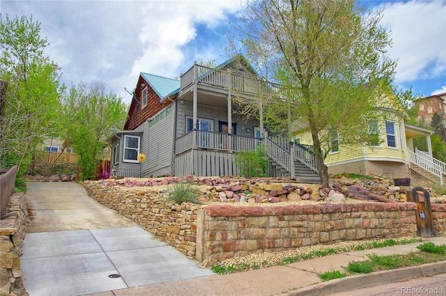 114 N 7th St, Colorado Springs, CO 80905 - view of front facade with stairs, concrete driveway, metal roof, and a balcony